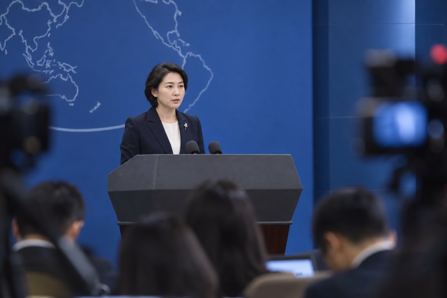 庄重的蓝色新闻发布厅内,一名女性发言人在记者与摄像机前作正式回应