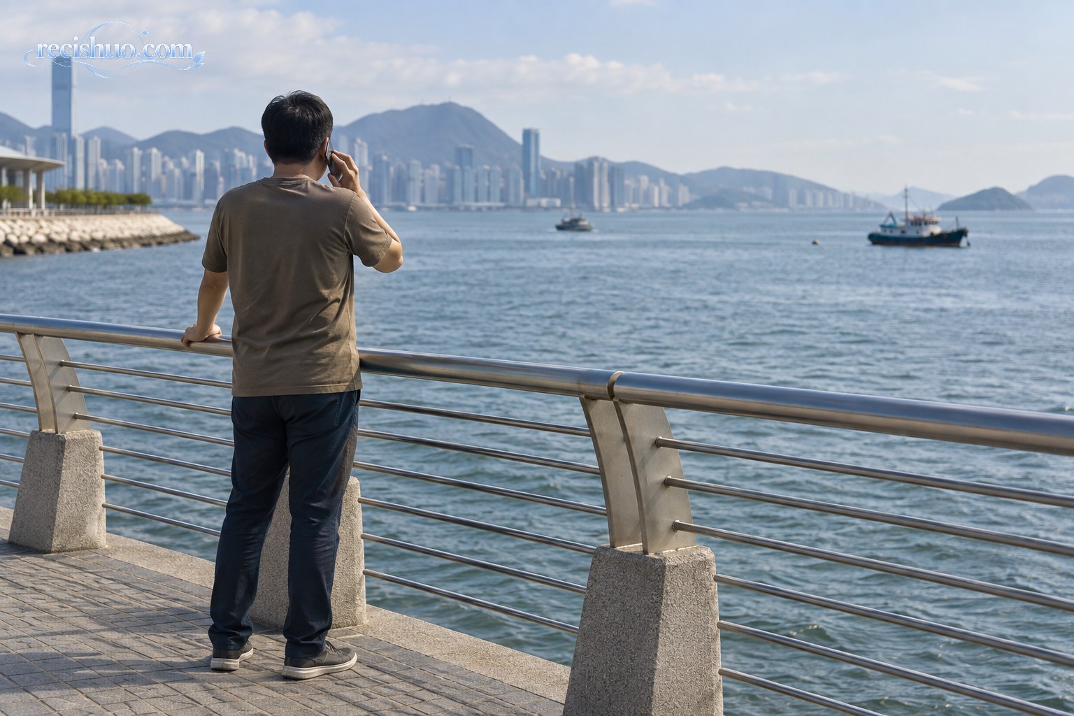 市民站在海滨护栏内侧观察水面并使用手机报警