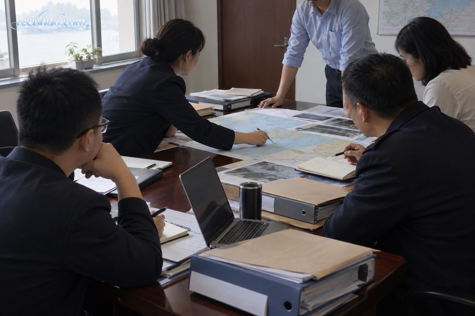工作人员围绕地图和卷宗核查运河岸线管理资料