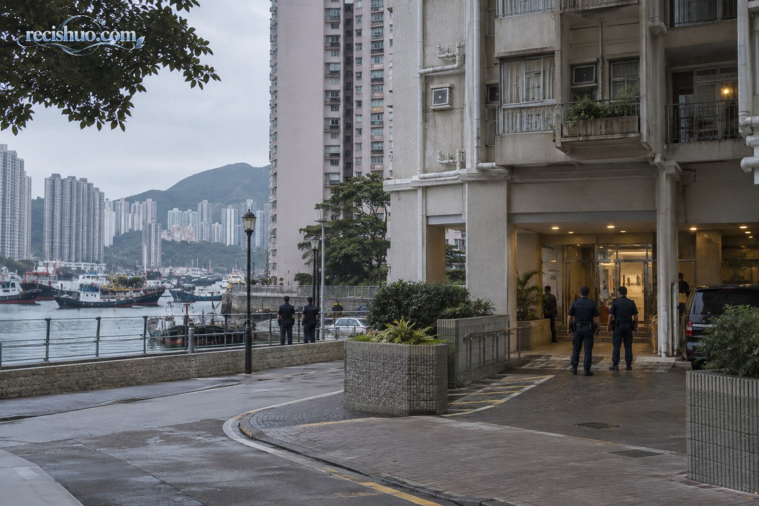 阴天清晨的香港临海住宅楼外,数名警务人员在入口附近跟进调查
