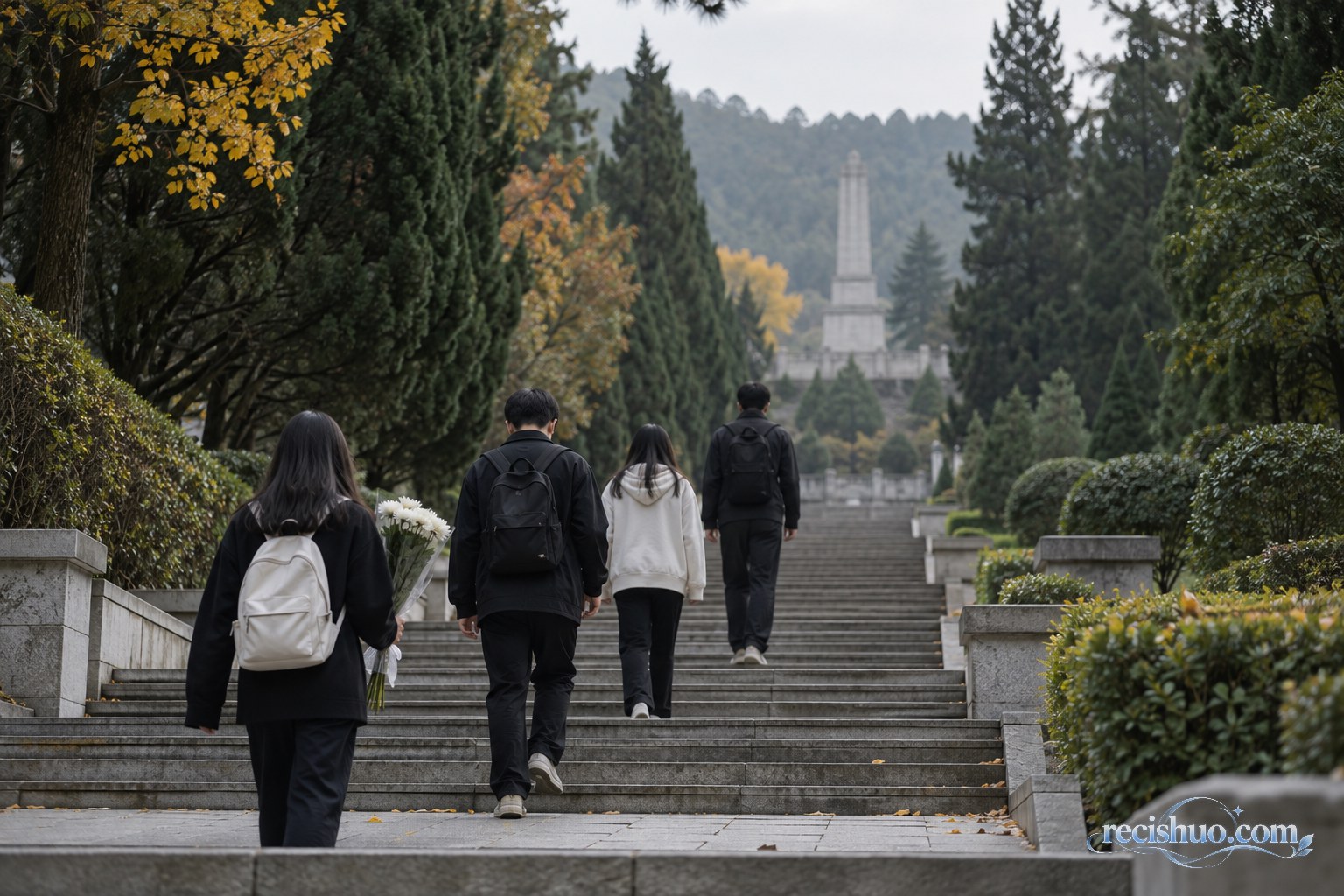 青年参访者手持白花沿松柏环绕的陵园石阶缓步前行