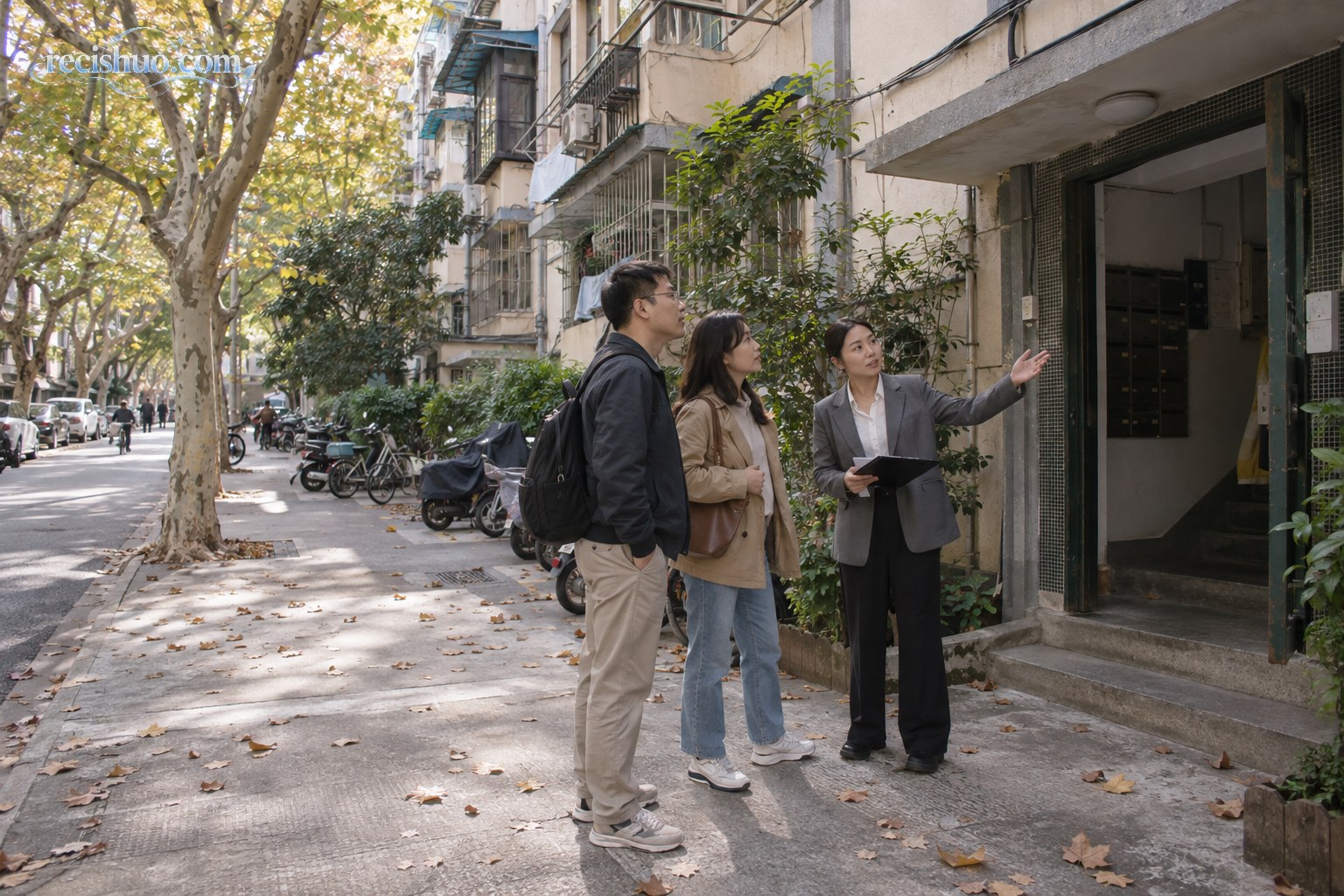 上海成熟老社区内,购房者在经纪人陪同下查看老式多层住宅