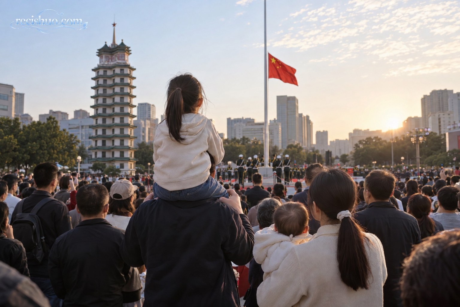 国庆清晨,一位父亲肩扛女儿、母亲怀抱宝宝在城市广场观看升旗仪式