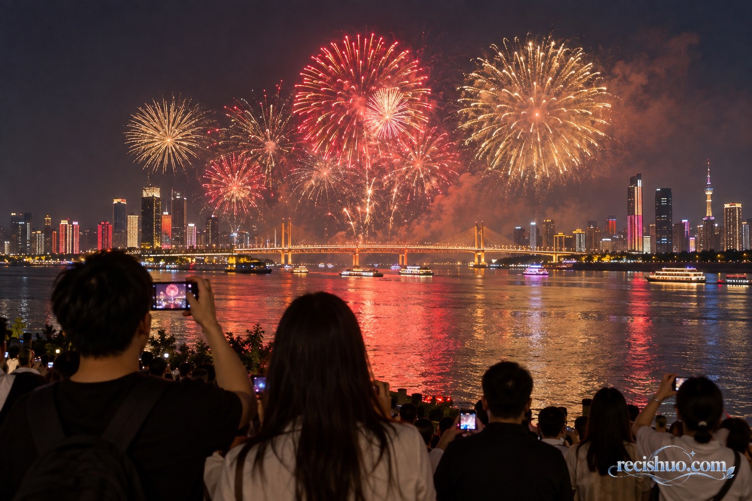 武汉江岸夜景与绚丽烟花相映,市民在安全观景区域用手机记录节日夜空