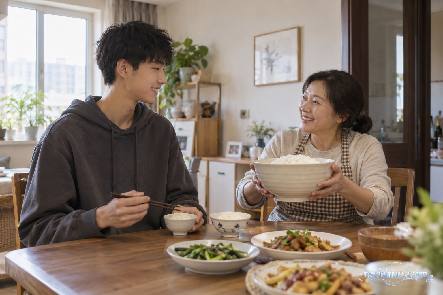 居家餐桌旁,母亲笑着端起巨型饭碗与高个少年轻松互动
