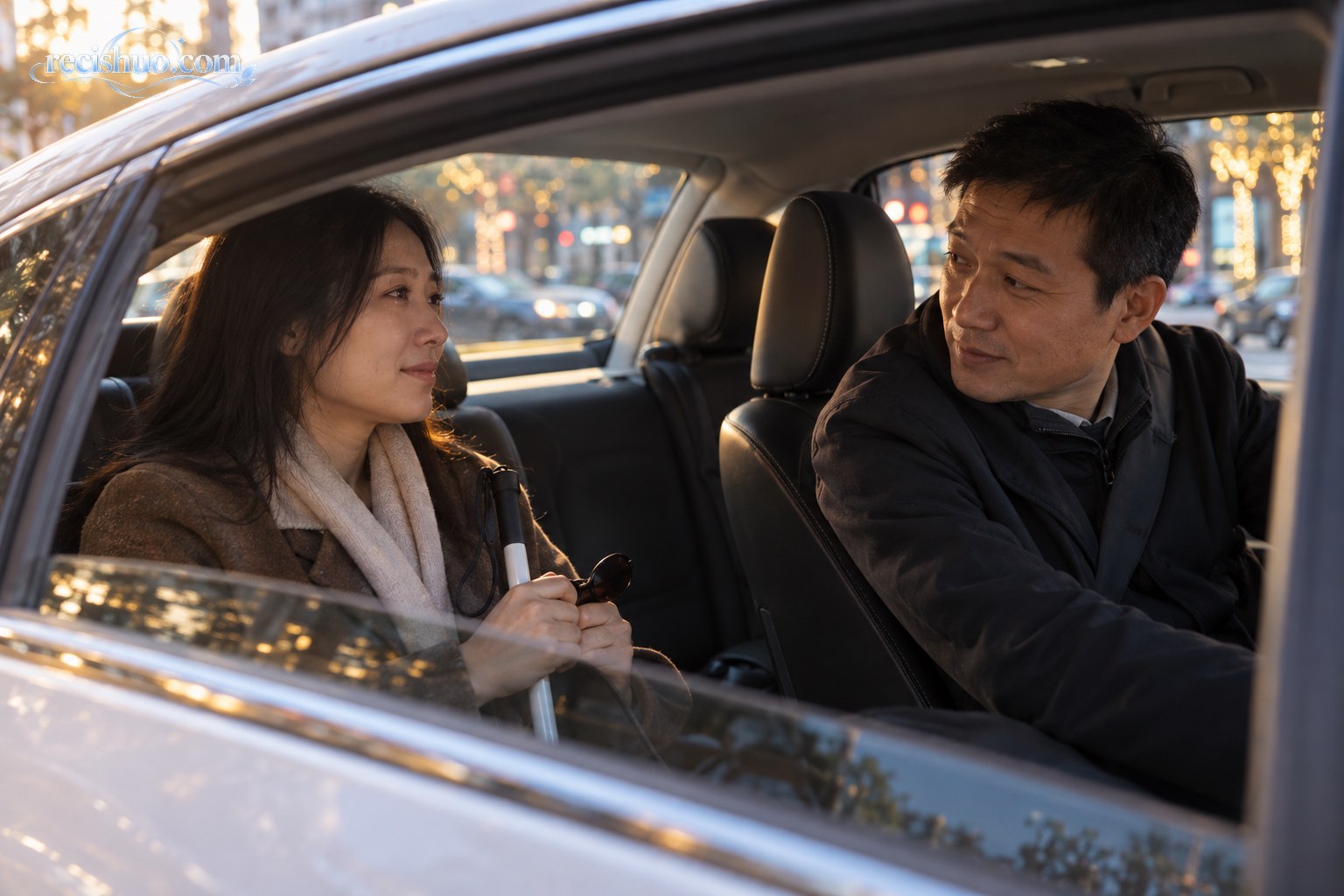 网约车内司机回身倾听一名手持盲杖和墨镜的视障乘客