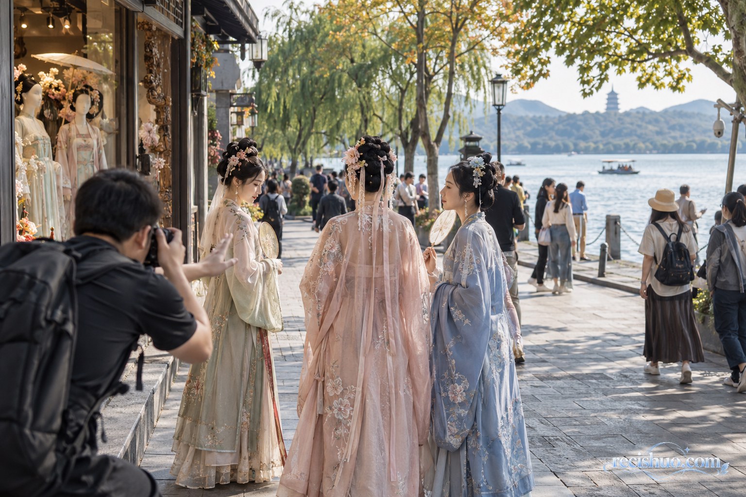 游客身着传统风格服装在西湖边拍照,摄影师与同行者协助完成取景