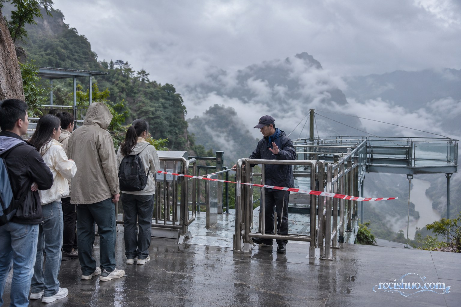 阴雨云雾天气下工作人员关闭高处体验项目入口并劝导游客等待