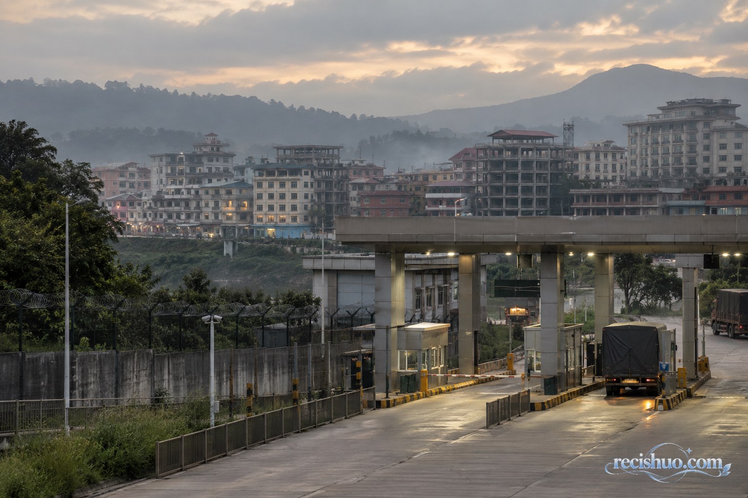 暮色下口岸通道与近距离境外建筑群构成的边境安全示意场景