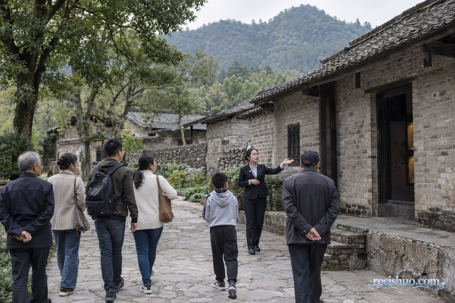 游客在山村旧址建筑前听讲解,沿石板路了解红色历史