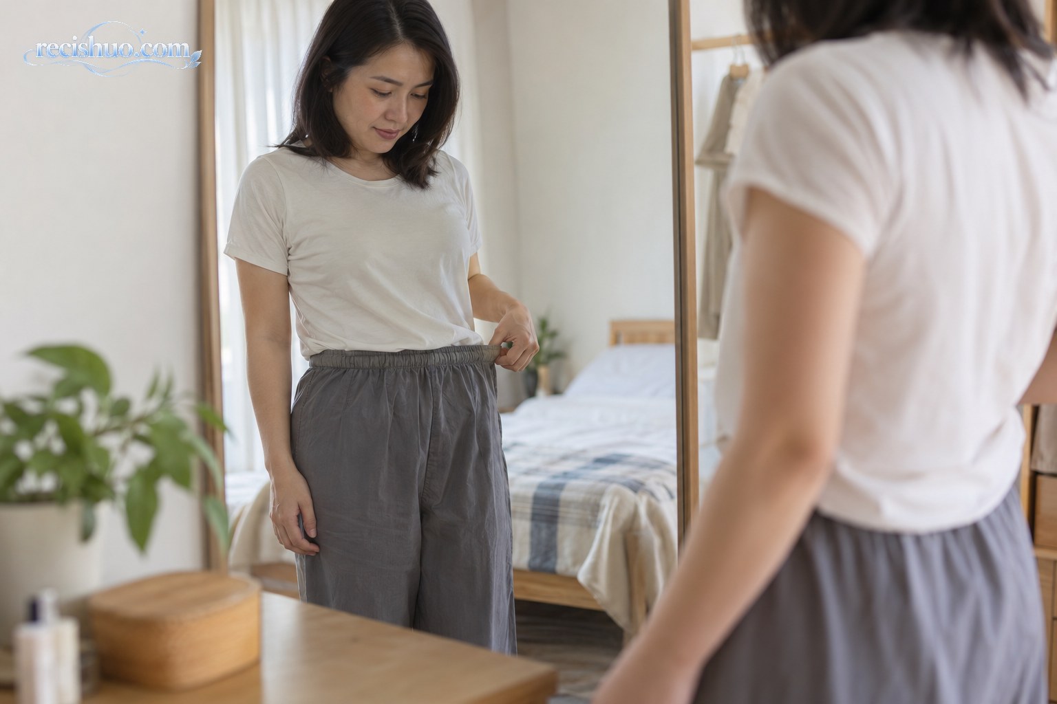 女性在镜子前查看裤腰松紧,留意近期腰围变化