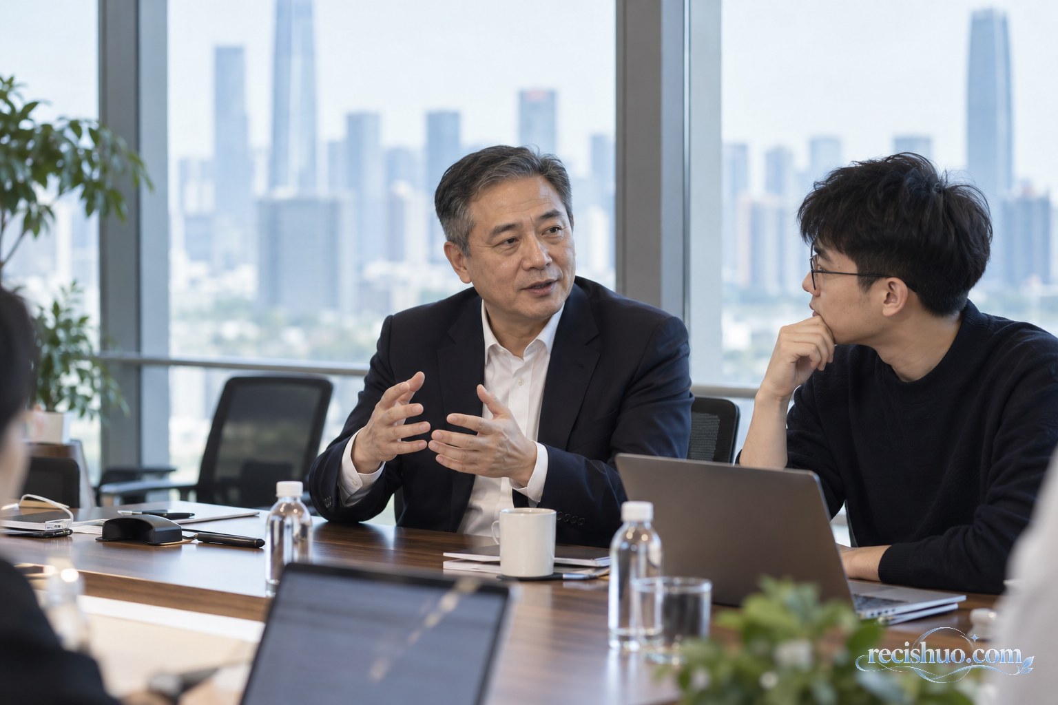 现代科技企业会议室内资深管理者与青年科研人员相邻交流的场景