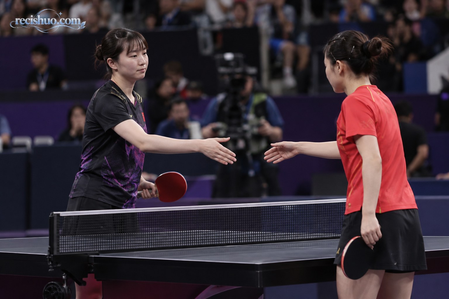 比赛结束后两名女子乒乓球选手隔网握手致意