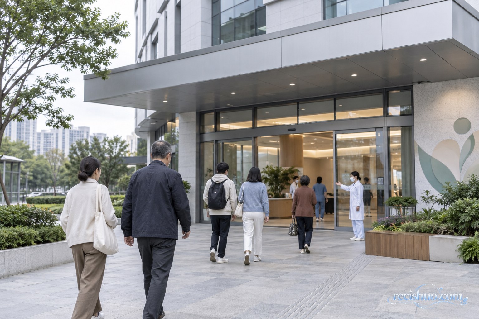市民与家属走向一座现代公立医院门诊楼,医护人员在入口处提供引导