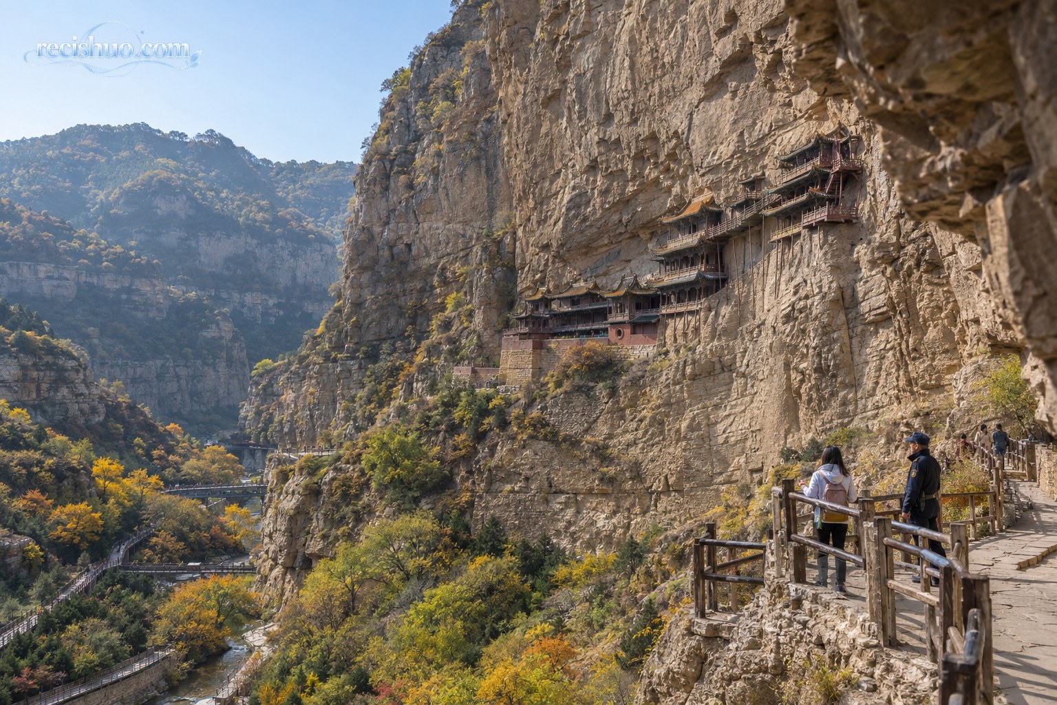山谷峭壁间的悬空古建筑与在安全护栏内参观的游客