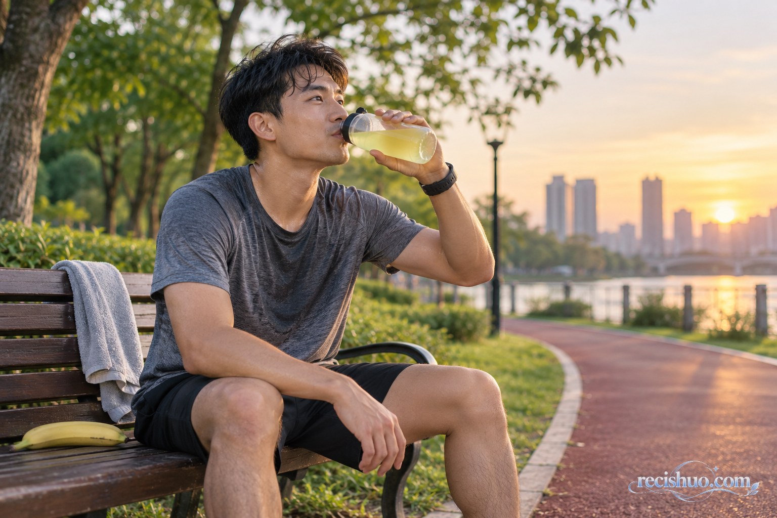 一名男子在公园慢跑后坐在长椅上小口补充饮品