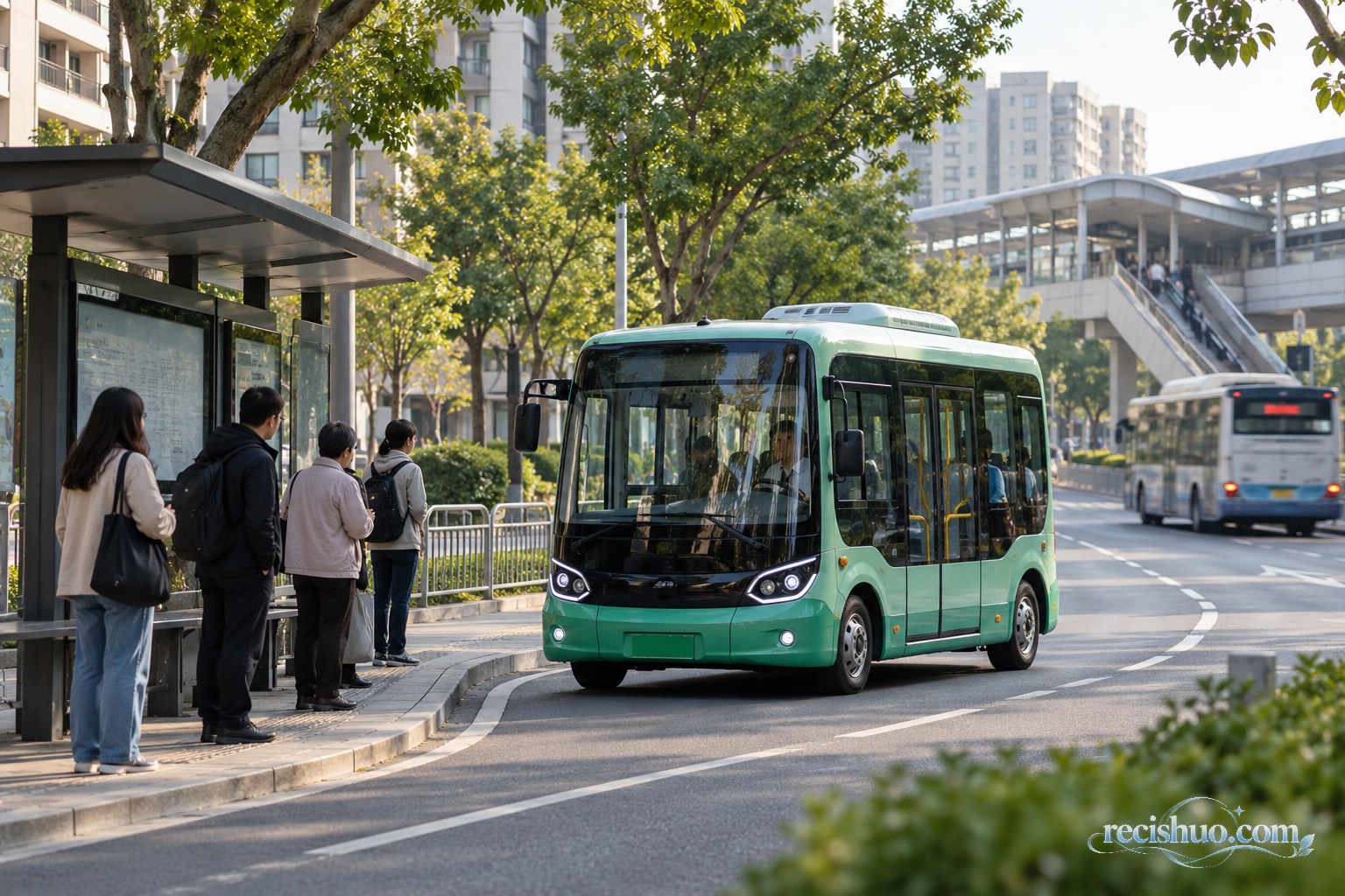 城市公交站旁,小型社区公交进站,远处传统大型公交驶过