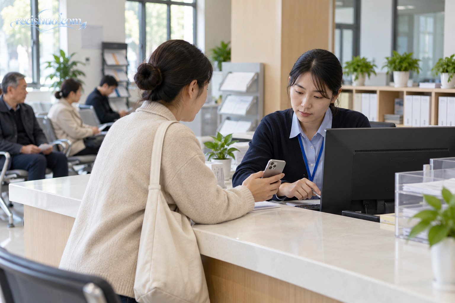 居民在社区公共服务窗口出示手机并向工作人员核验补偿通知