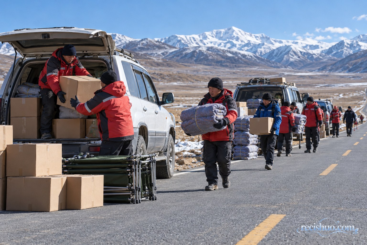 救援人员在雪山下的高原公路旁接力转运毛毯、折叠床和成箱物资