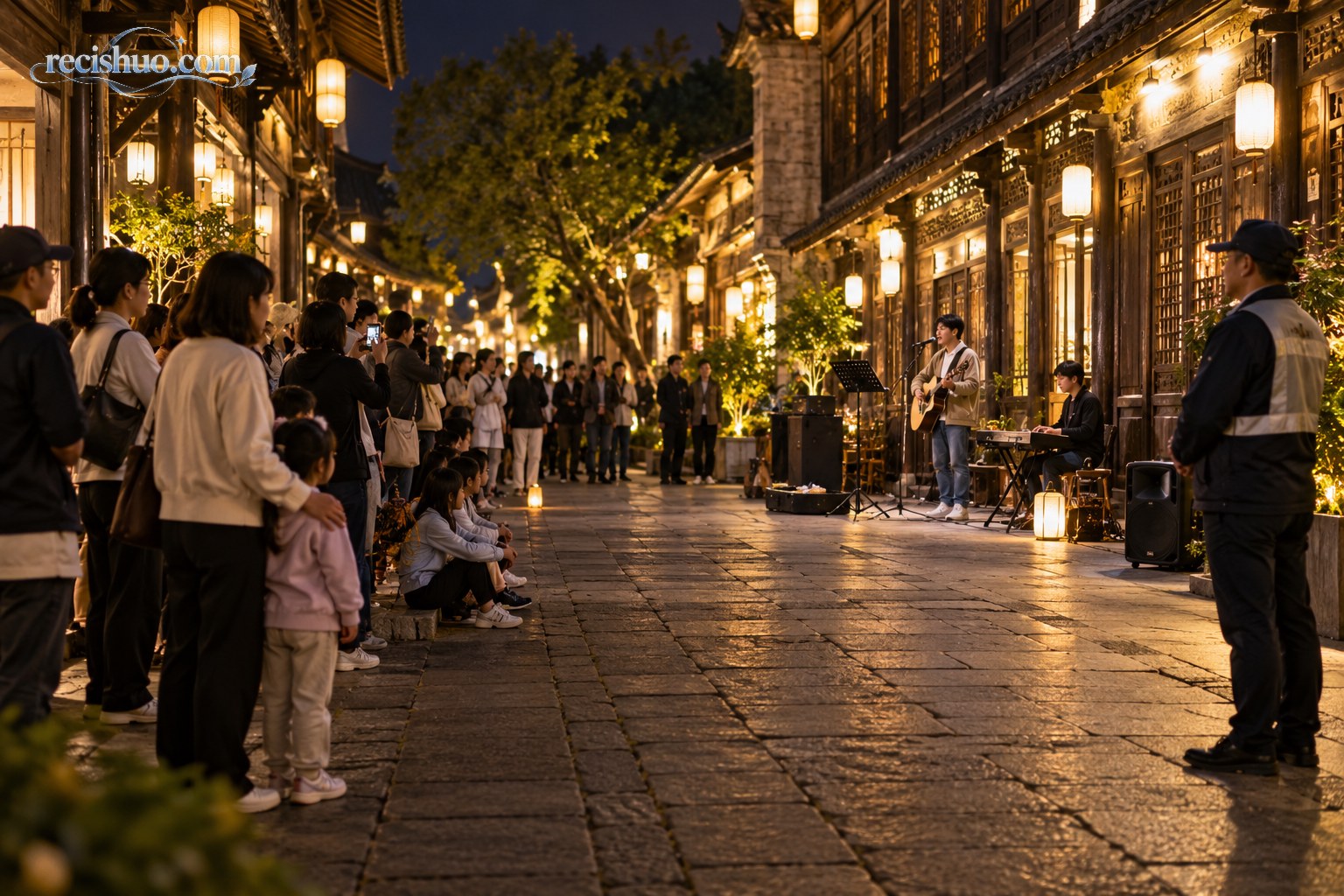 夜间老街歌唱表演现场，游客留出通行空间文明观看，工作人员在一旁维护秩序