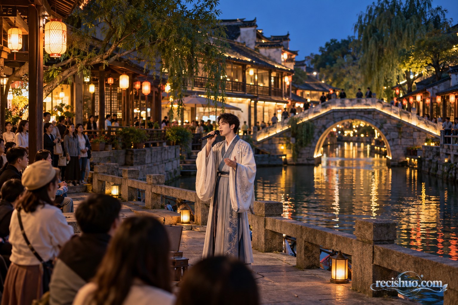 夜色老街河畔,一名古风装束的驻场演员在暖灯与石桥前演唱,游客有序观看