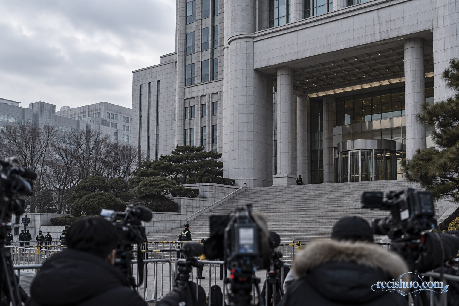 阴天里的现代法院建筑外聚集着等候采访的媒体人员