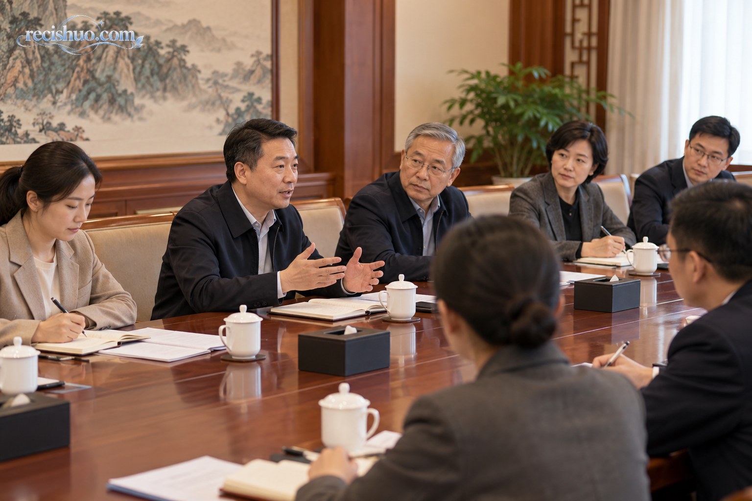 正式会议室内多位与会者围桌交流并认真记录意见