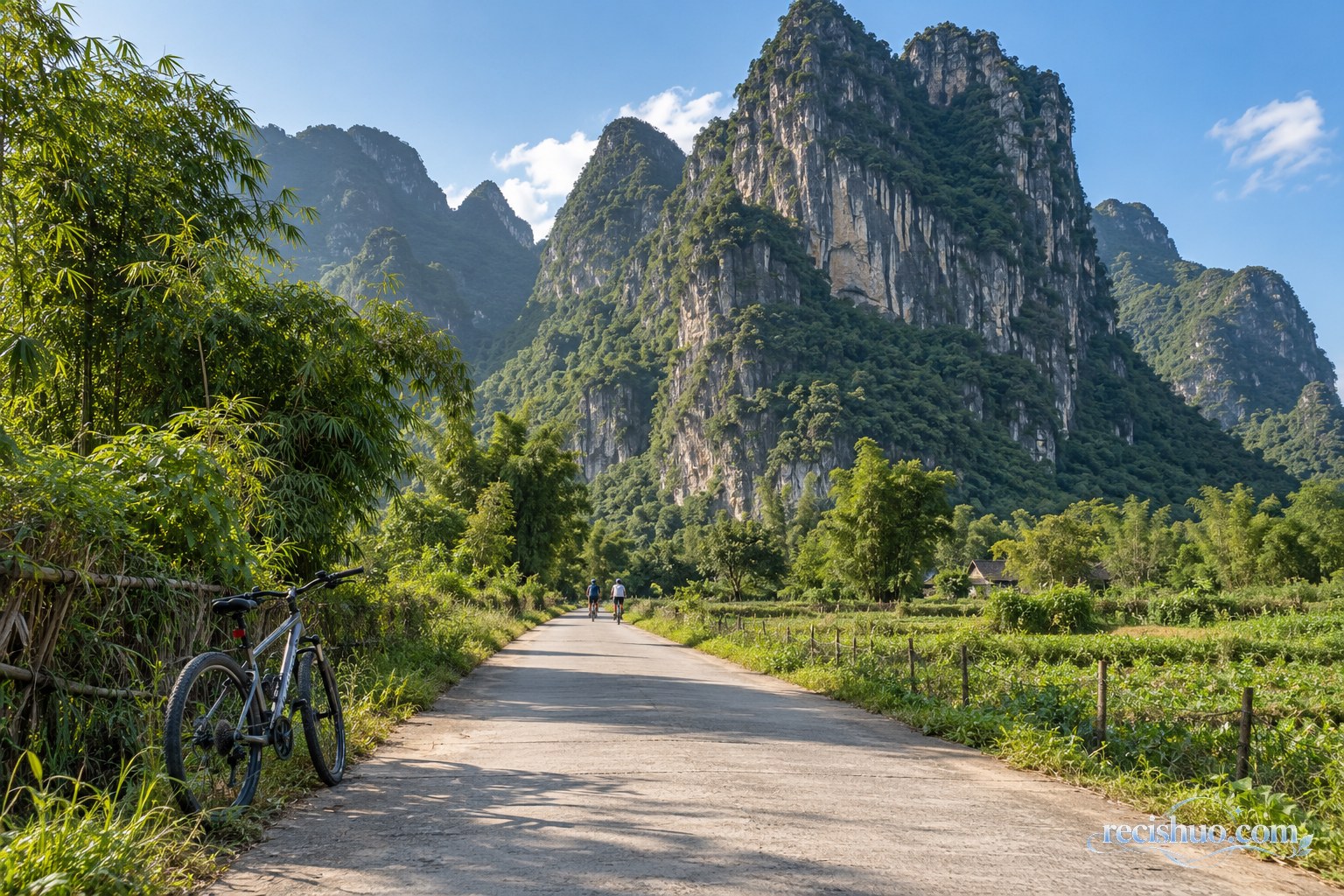 阳朔乡间公路直通高耸峰林,路边自行车与远处骑行者形成尺度参照